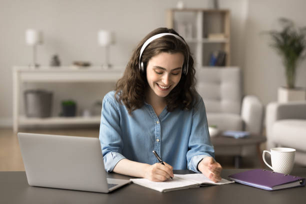 istock Beautiful smiling student girl makes assignment at home 2163907076