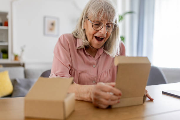 istock Elderly woman opening a package 2163911551