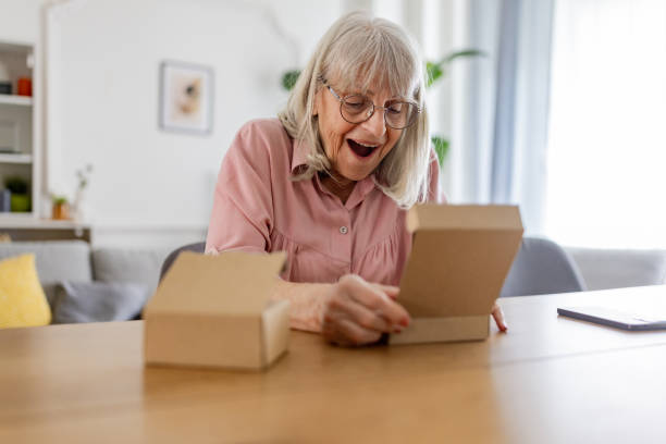 istock Senior woman opening a package 2163911580