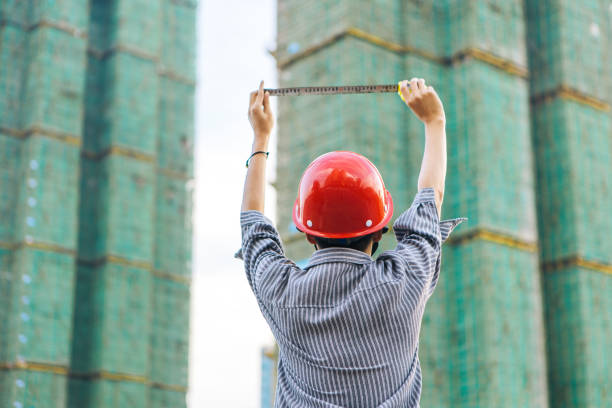 An Asian engineer in front of an unfinished building