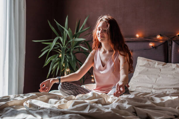istock Peaceful young active woman practicing yoga on the bed 2163916600