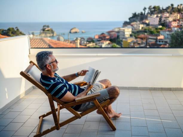 istock Man reading a book on the balcony 2163921272