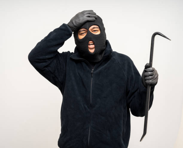 istock Thief in uniform black jacket various pose on isolated background. The Robber terrorism criminal escapes with balaclava and crowbar entering a house for stealing Housebreak 2163921326