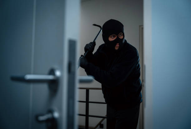 istock Thief in uniform black jacket various action housebreak. The Robber terrorism criminal escapes with balaclava and crowbar entering a house for stealing Housebreak at night 2163922234