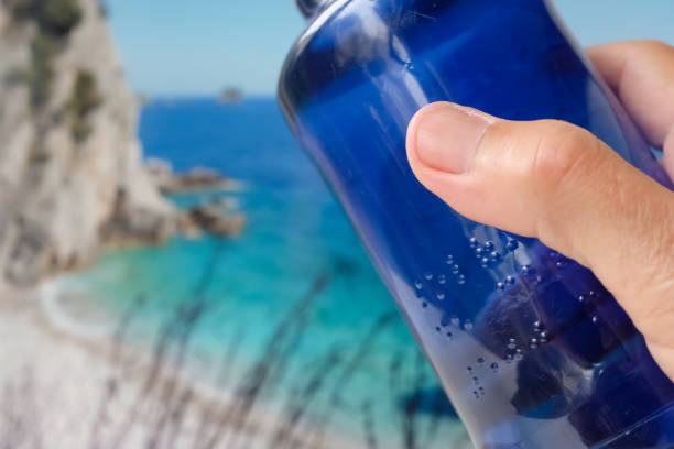 Braille font on a plastic water bottle. Raised dots on the plastic bottle. Person reads Braille. Read with fingers. Braille printing for plastic packaging. Accessibility for Persons with Disabilities.