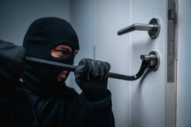 istock Thief in uniform black jacket various action housebreak. The Robber terrorism criminal escapes with balaclava and crowbar entering a house for stealing Housebreak at night 2163923905