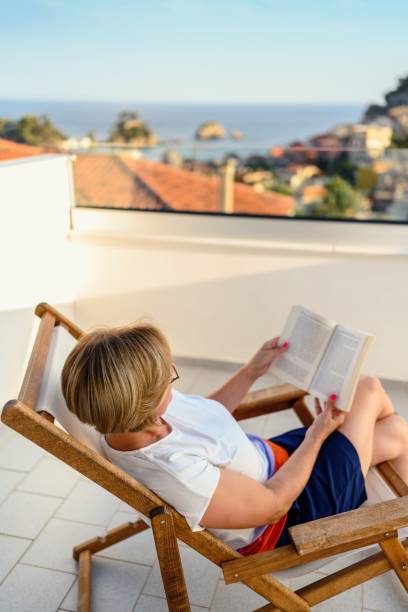 istock Woman reading a book on the balcony 2163923993