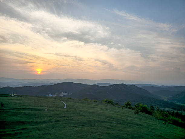 istock A beautiful sunset over a mountain range with a path leading to the top. The sky is filled with clouds, creating a serene and peaceful atmosphere 2163924506