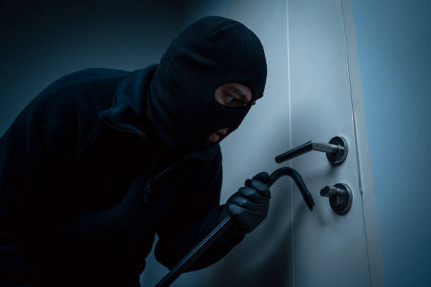 istock Thief in uniform black jacket various action housebreak. The Robber terrorism criminal escapes with balaclava and crowbar entering a house for stealing Housebreak at night 2163924682