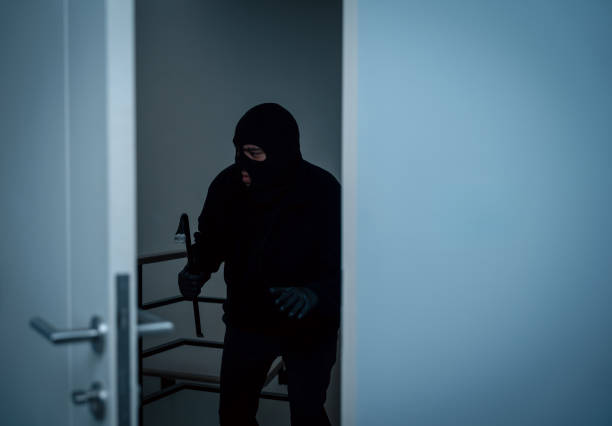 istock Thief in uniform black jacket various action housebreak. The Robber terrorism criminal escapes with balaclava and crowbar entering a house for stealing Housebreak at night 2163925036