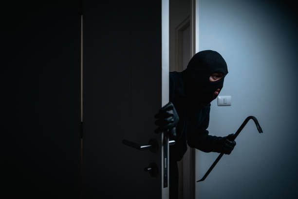 Thief in uniform black jacket various action housebreak. The Robber terrorism criminal escapes with balaclava and crowbar entering a house for stealing Housebreak at night