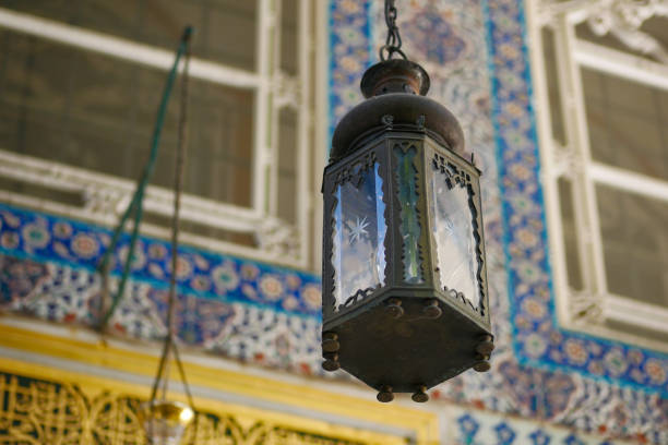 Intricately designed hanging lantern set against a vibrant, patterned tile wall.