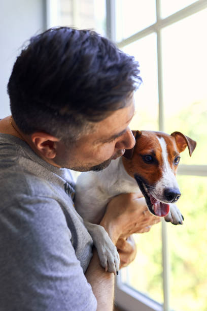 istock Adorable man and lovable pretty Jack Russel terrier 2163927315