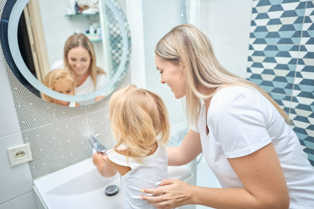 istock mom teaches child hands washing 2163933112
