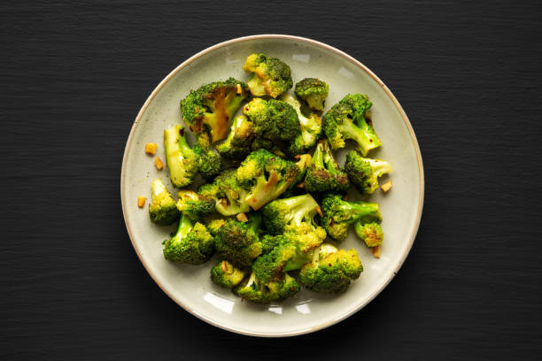 istock Homemade Pan-Fried Broccoli on a Plate on a black background, top view. Flat lay, overhead, from above. Space for text. 2163933128