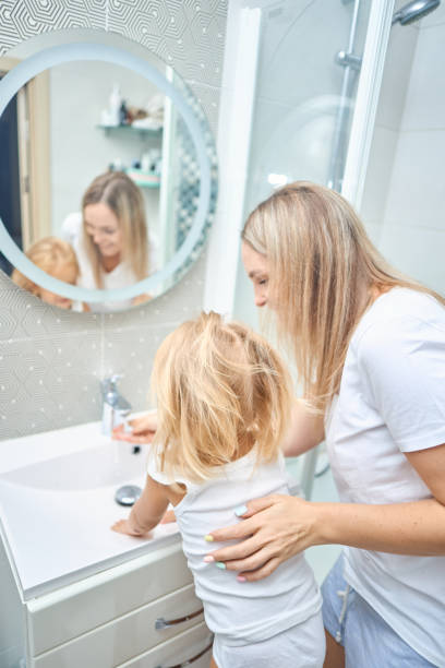 istock mom teaches child hands washing 2163933135
