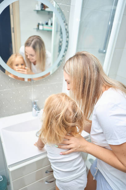 istock mom teaches child hands washing 2163933839