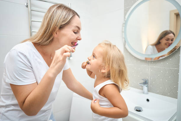 istock Woman and child brushing each other's teeth 2163934060