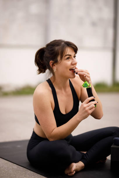 istock Woman eating nutrition stick pack after exercising 2163936800