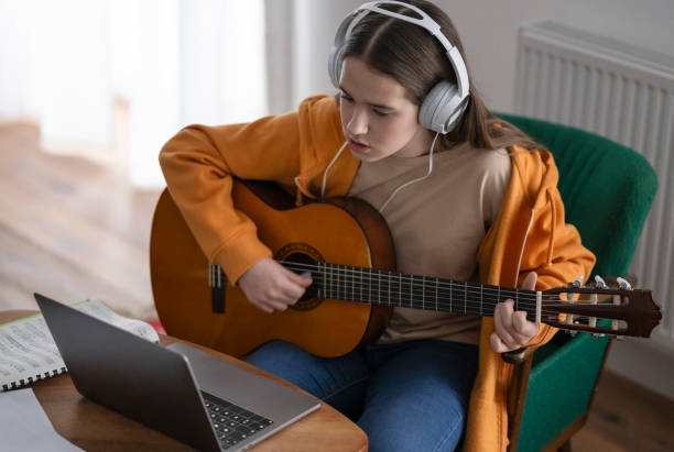 istock Focused Beginner Guitarist Practices at Home 2163937111