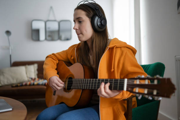 istock Focused Beginner Guitarist Practices at Home 2163937118