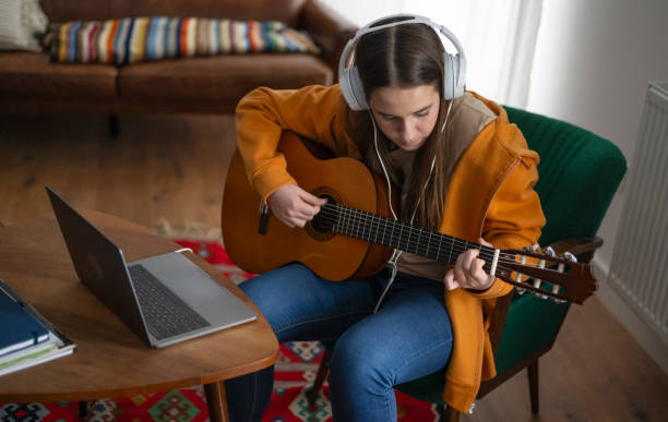 istock Focused Beginner Guitarist Practices at Home 2163937122