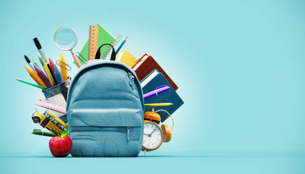 istock Blue backpack with alarm clock and school equipment. Back to school concept on blue background with copy space. 2163941408