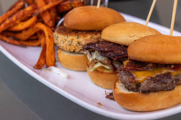 istock Three small sliders with different ingredients on buns, with a side of fries 2163941784