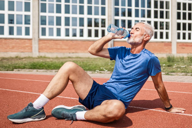 istock Confident mature athlete runner taking a break drinking water 2163948467