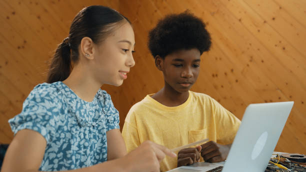 istock Site view of african boy and girl working together to code prompt. Edification. 2163953852