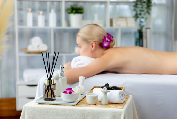 Aromatherapy massage on daylight ambiance or spa salon composition setup with focus decor and spa accessories on blur woman enjoying blissful aroma spa massage in resort or hotel background. Quiescent