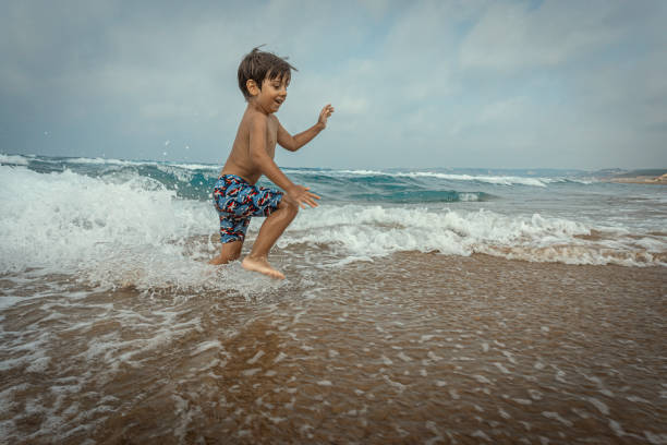 istock Boy playing on the seashore on the beach. 2163968094