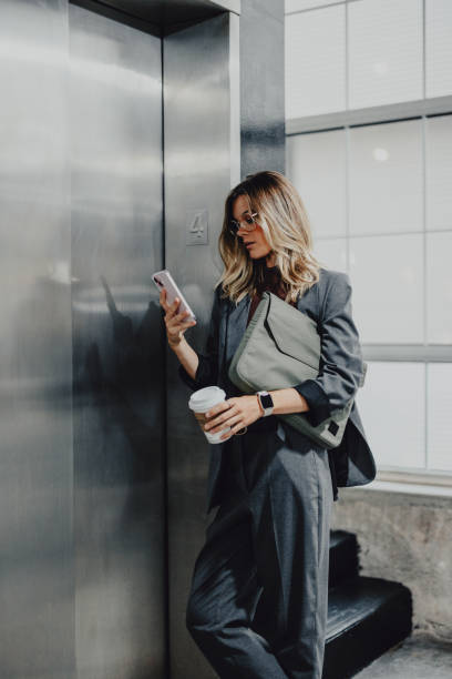Businesswoman Using Smartphone in a City Street Elevator