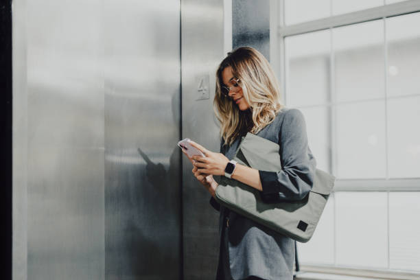 istock Businesswoman Using Smartphone In Modern Office Building 2163968690