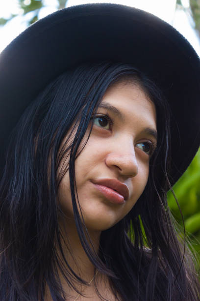 Portrait of a young latin woman with tender look and a black hat
