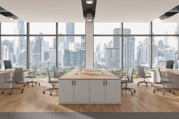 istock Cozy coworking interior with armchairs and desks, pc computers and window 2163972136