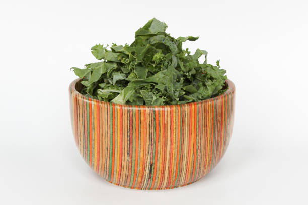 Bowl of chopped kale in colorful bowl on white background