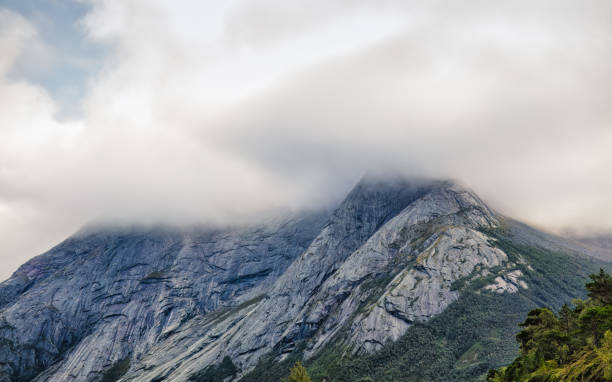 Moody mountain peak shrouded in mist. . North Norway