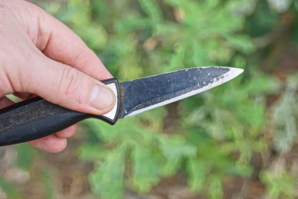 istock hand holds a black old knife on a green background 2163973093