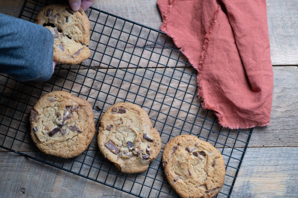 istock Hands breaking apart a chocolate chunk cookie cooling on a wire rack. 2163977088