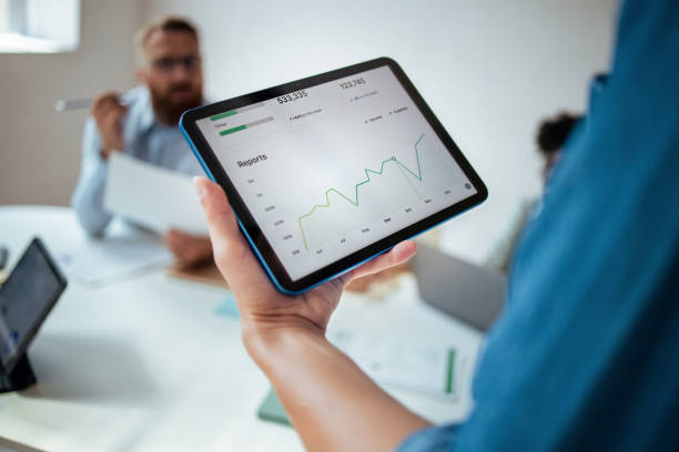 Business Team Meeting Analyzing Financial Reports on Tablet