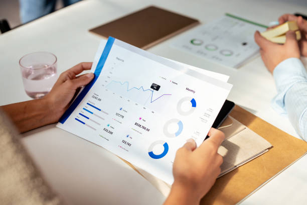 Business Meeting with Financial Documents and Graphs