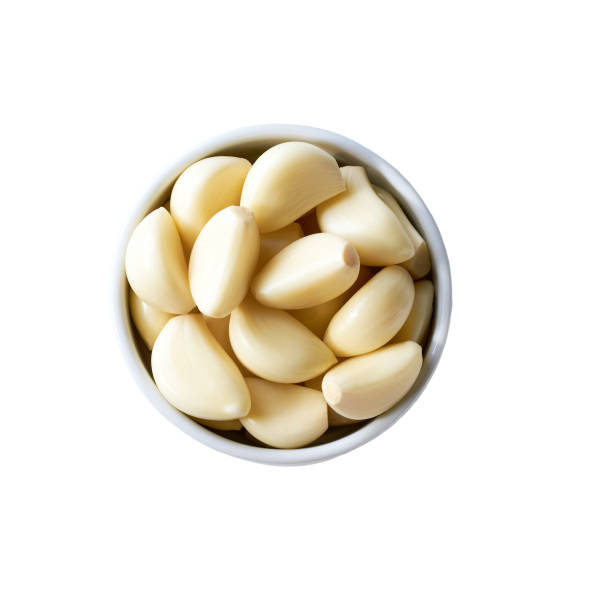 istock garlic in a ceramic bowl isolated on white background, top view. 2163981516