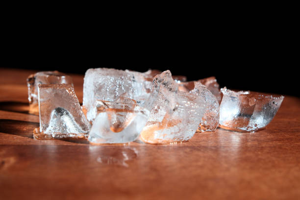 istock Ice cubes on a wooden table. Black background. Close up. 2163981698