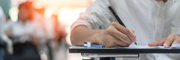 istock Exam at school with student's taking educational admission test in class, thinking hard, writing answer in university classroom, education and world literacy day concept 2163983267