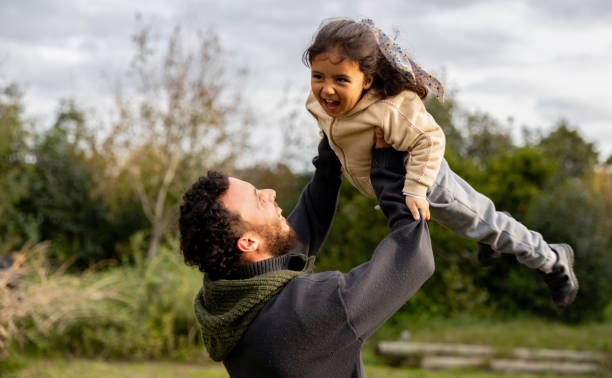 istock Happy father playing with his daughter outdoors spinning her around 2163991079