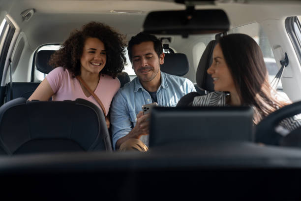 istock Crowdsourced taxi driver driving a happy couple using a transportation app 2163991694