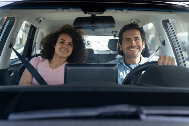 istock Happy couple going on a road trip in their car 2163991711