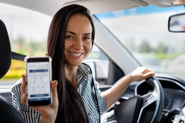 istock Crowdsourced taxi driver showing a mobile app on her cell phone 2163991759