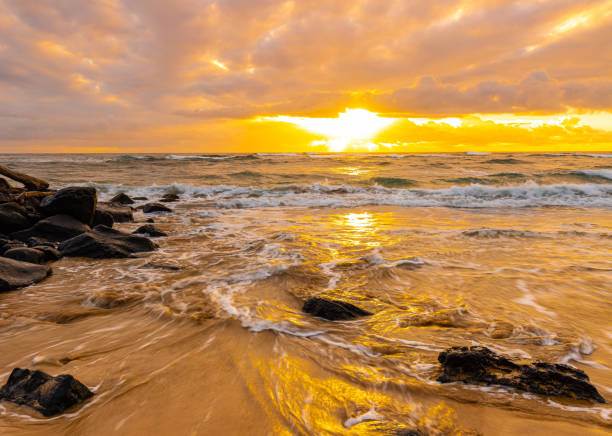 Waves Washing Over Sand and Rocks at Sunrise, Lydgate Beach Park, Kauai, Hawaii, USA